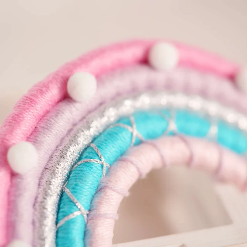 Arco-Íris artesanal com fios de algodão em tons pastel de rosa, lilás e azul, inspirado em algodão doce, ideal para decoração de quartos infantis e baby showers
