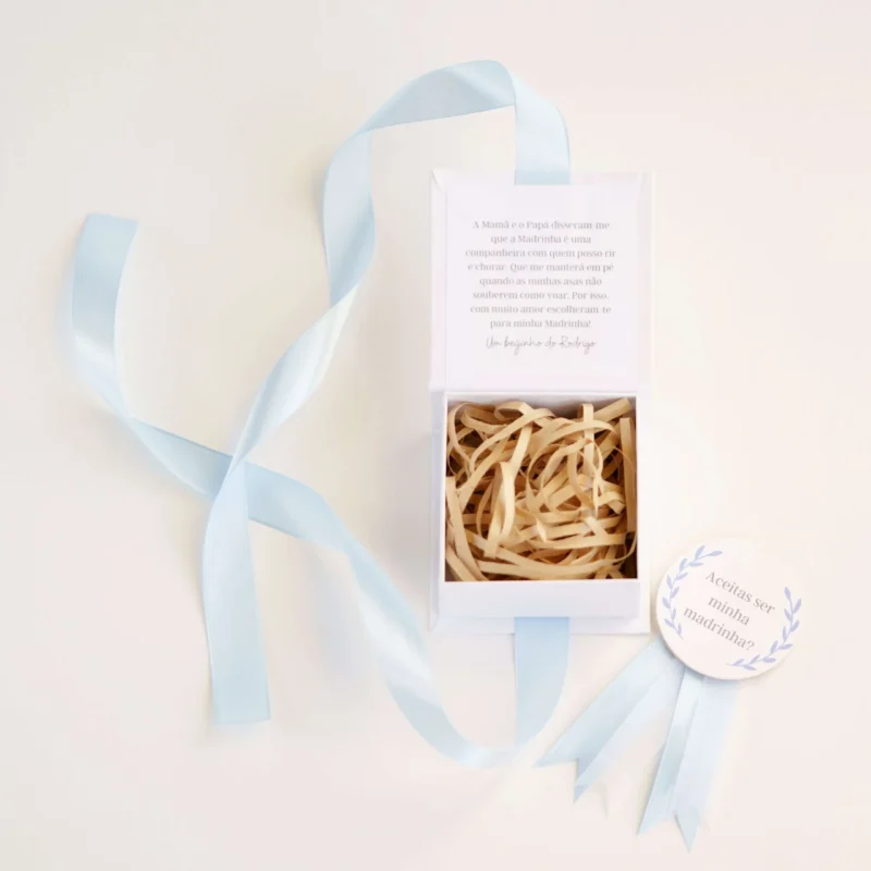 Caixa convite personalizada com mensagem para madrinha ou padrinho, decorada com fita de cetim e detalhe de medalhão em madeira com a inscrição 'Aceitas ser minha madrinha/padrinho?'