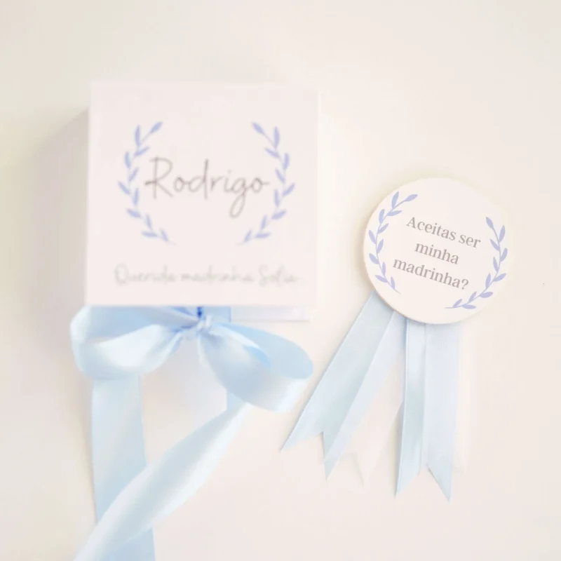 Caixa convite personalizada com mensagem para madrinha ou padrinho, decorada com fita de cetim e detalhe de medalhão em madeira com a inscrição 'Aceitas ser minha madrinha/padrinho?'