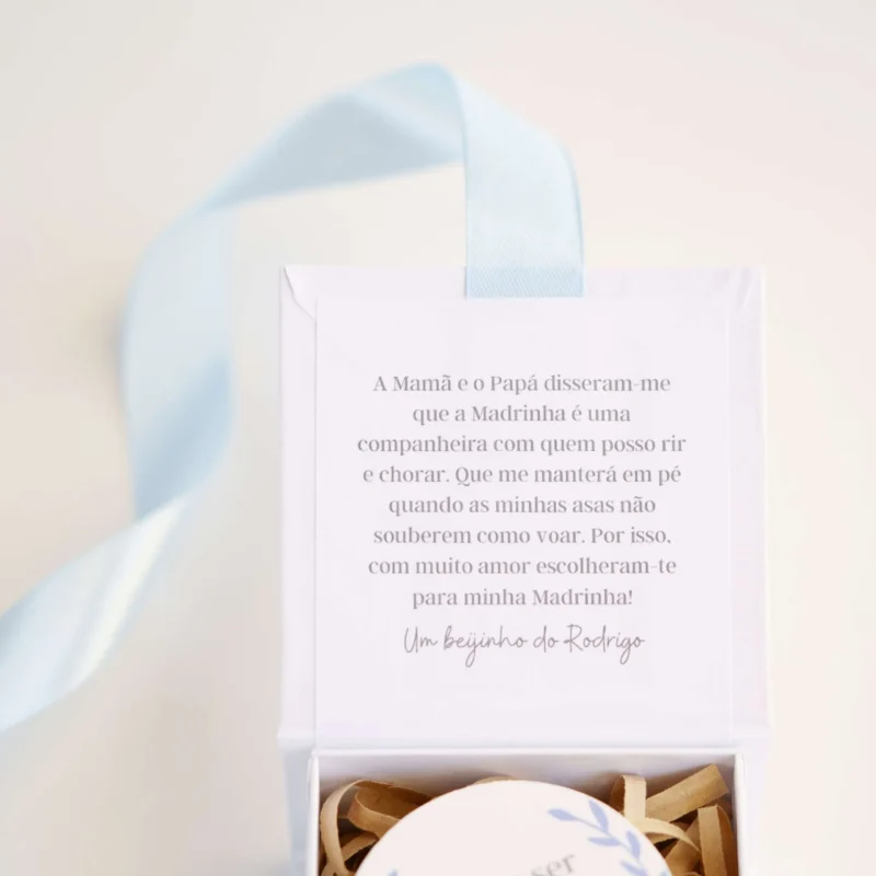 Caixa convite personalizada com mensagem para madrinha ou padrinho, decorada com fita de cetim e detalhe de medalhão em madeira com a inscrição 'Aceitas ser minha madrinha/padrinho?'
