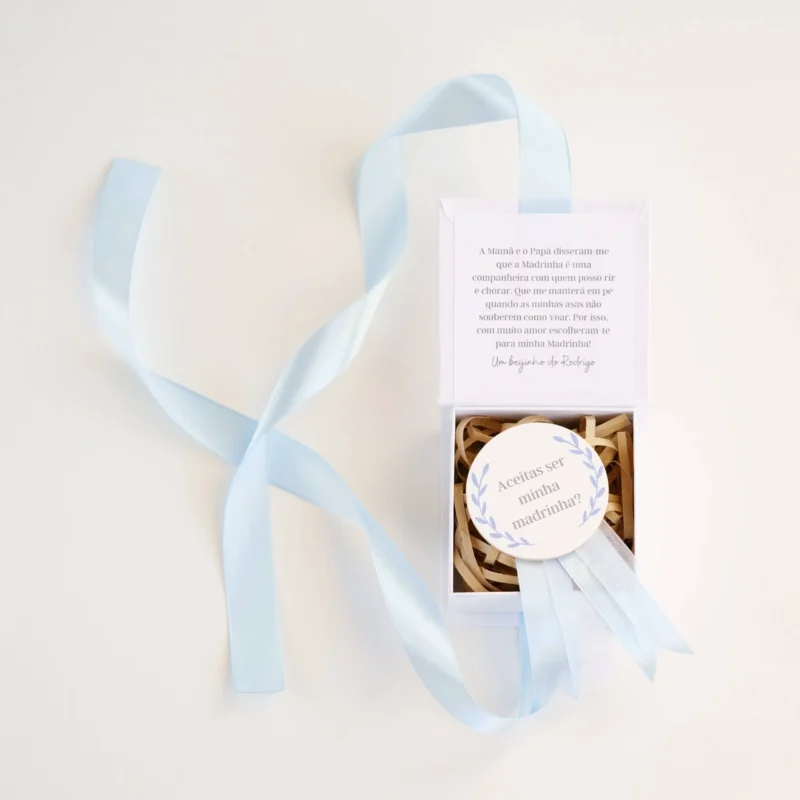 Caixa convite personalizada com mensagem para madrinha ou padrinho, decorada com fita de cetim e detalhe de medalhão em madeira com a inscrição 'Aceitas ser minha madrinha/padrinho?'