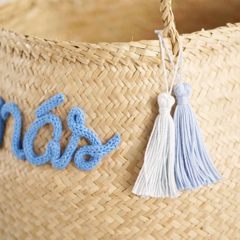 Cesto redondo personalizado em palha natural com o nome 'Tomás' em corda azul, ideal para organização e decoração de quartos de bebé