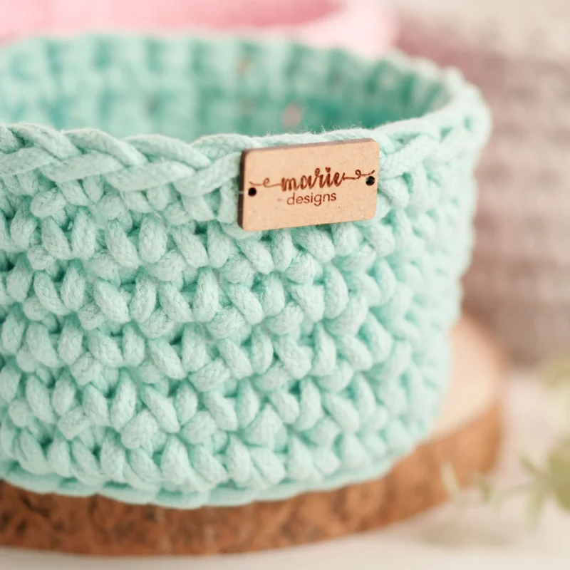 Conjunto de três cestos feitos à mão em crochet, em tons pastel, com uma estética decorativa e funcional