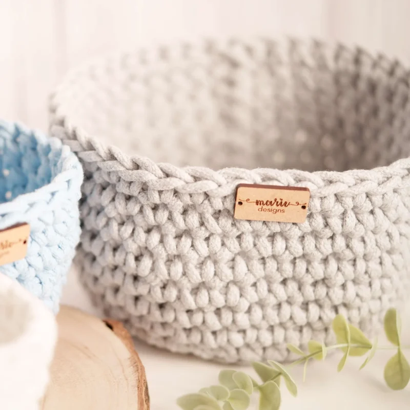Conjunto de três cestos feitos à mão em crochet, em tons pastel, com uma estética decorativa e funcional
