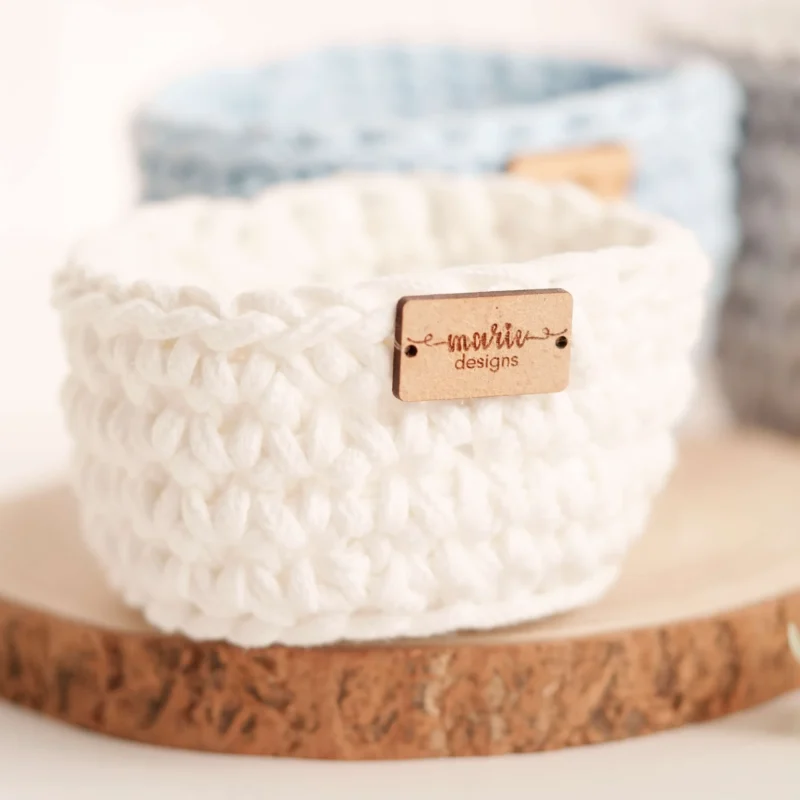 Conjunto de três cestos feitos à mão em crochet, em tons pastel, com uma estética decorativa e funcional