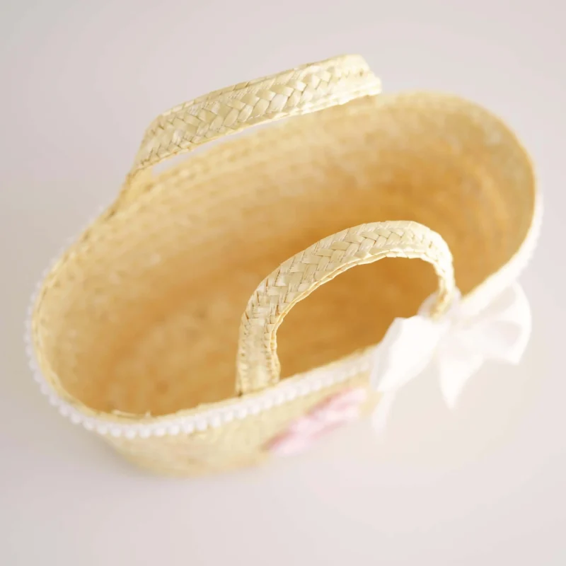 Mala de palha para criança decorada com inicial em crochet, laço branco e detalhes delicados