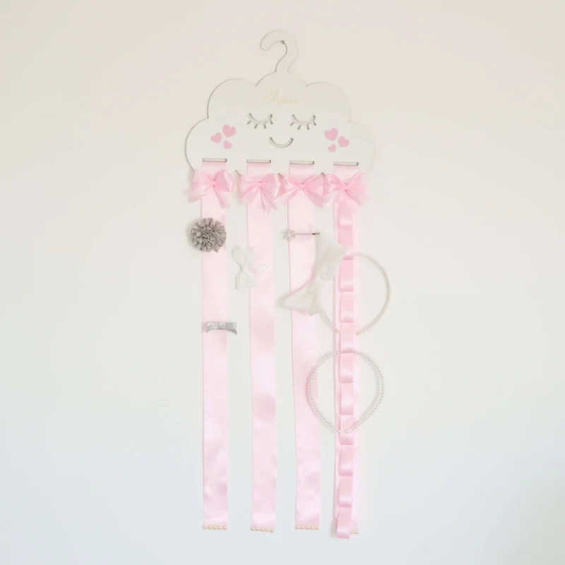 Porta laços em formato de nuvem branca com fitas de cetim rosa, detalhes de laços decorativos e espaço para organizar acessórios infantis
