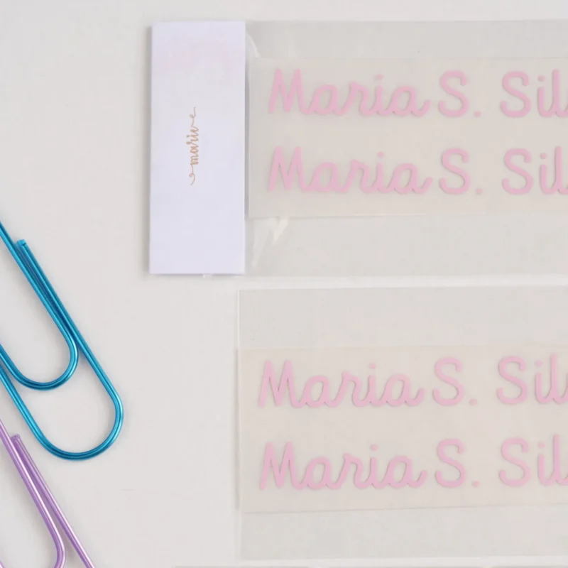 Etiquetas escolares termoaderentes personalizadas com nome, aplicáveis em tecidos como mochilas, estojos e roupa escolar com ferro de engomar