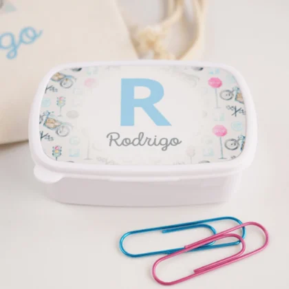 Lancheira personalizada branca com tampa decorada com inicial e nome “Rodrigo” em azul, rodeada por ilustrações coloridas