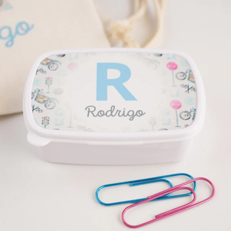 Lancheira personalizada branca com tampa decorada com inicial e nome “Rodrigo” em azul, rodeada por ilustrações coloridas