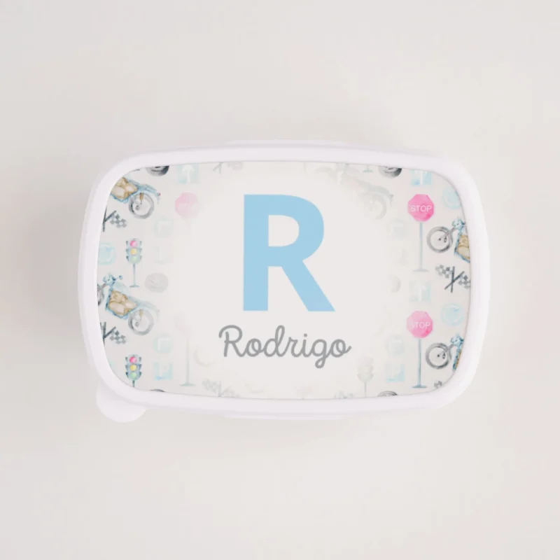 Lancheira personalizada branca com tampa decorada com inicial e nome “Rodrigo” em azul, rodeada por ilustrações coloridas
