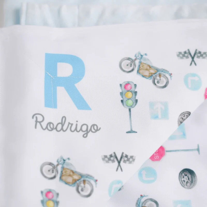 Manta personalizada em tecido macio azul, com nome “Rodrigo” e ilustrações de motos e sinais de trânsito